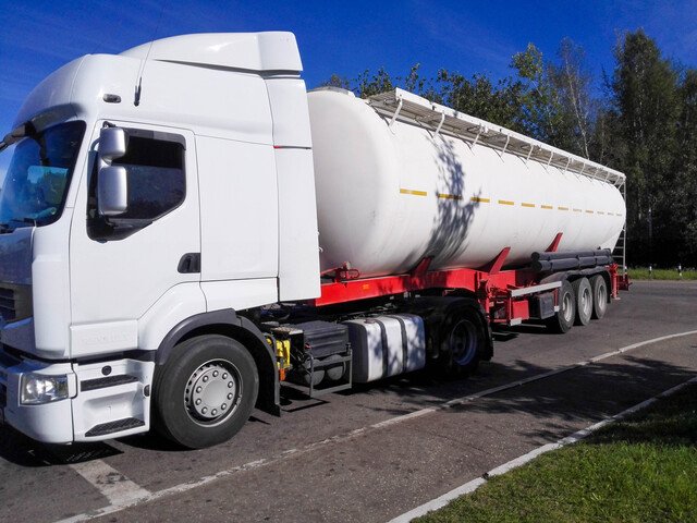 large white lorry with a tank container for liquid or gaseous dangerous goods